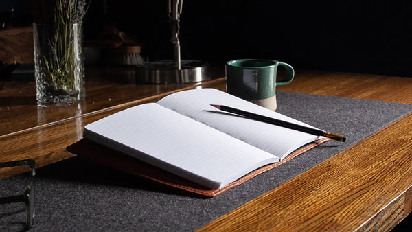 Open journal with a cup of tea set up on a desk